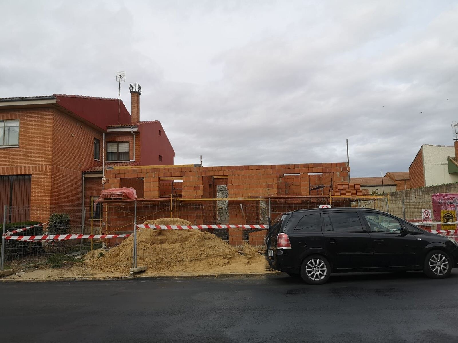 Obra nueva en construcción, fachada de ladrillo vista desde la calle