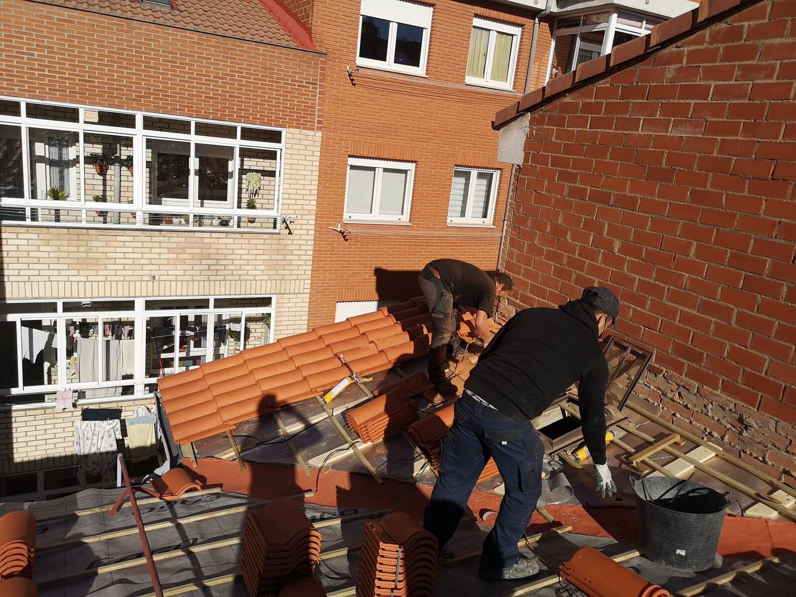Equipo de Construcciones Alfredo e Hijos colocando tejas en cumbrera