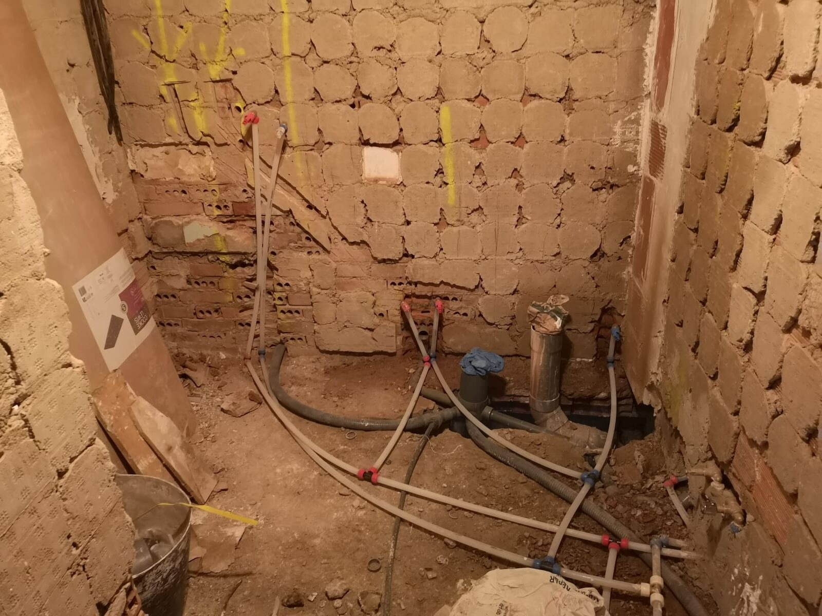 Instalación de fontanería en muro durante la obra